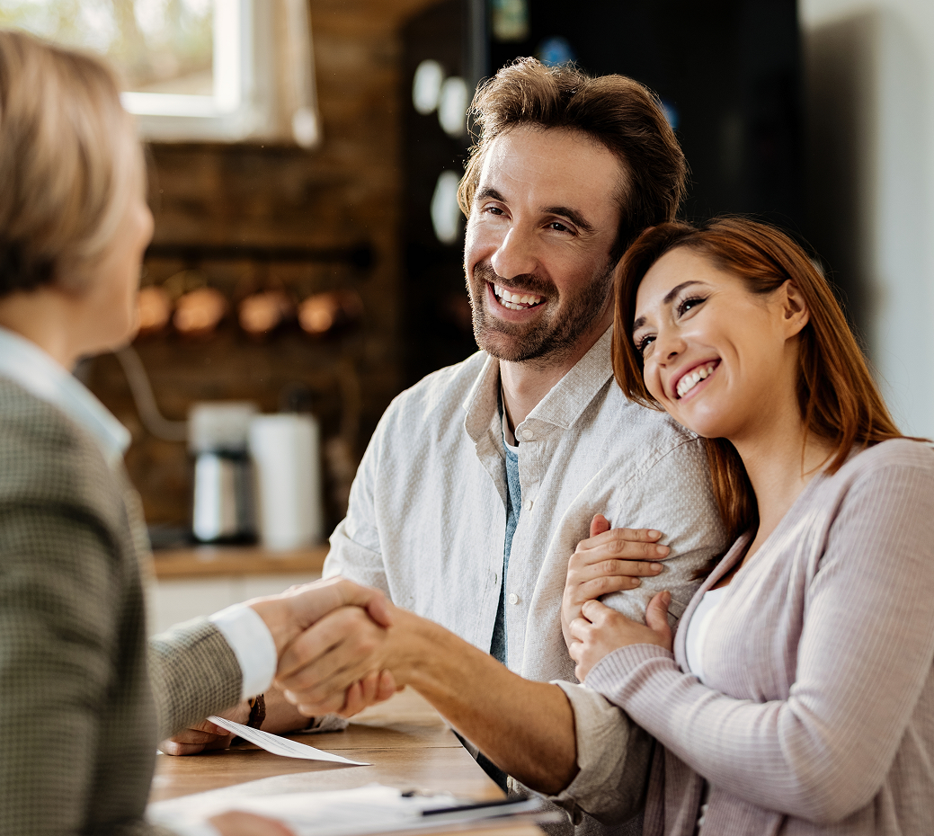 Advisor shaking hands with a couple across a table