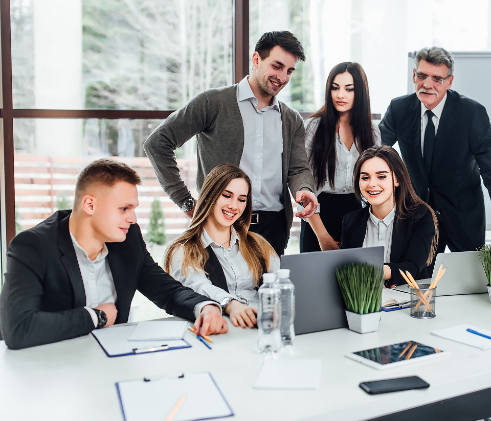 Colleagues in a business meeting around a laptop